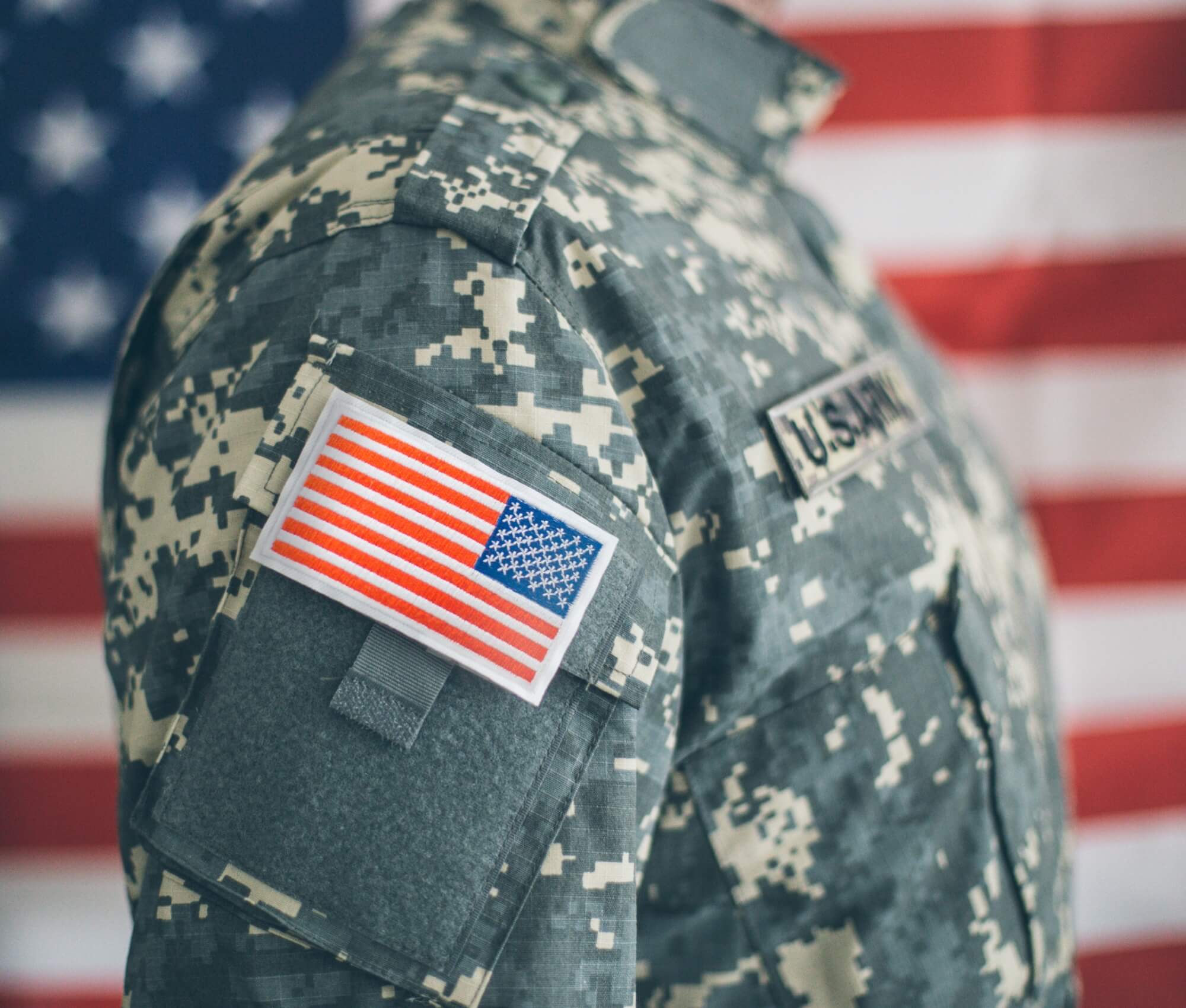 military personnel standing in front of flag